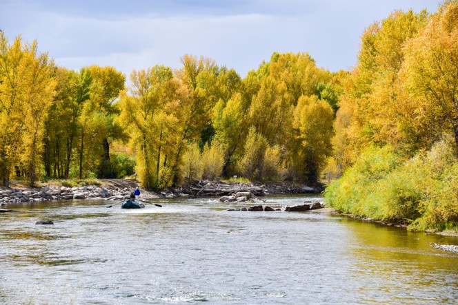 Two fishers rowing down a river in Colorado.